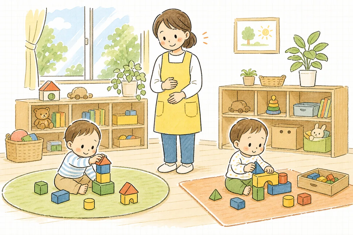 保育室で少し離れた場所に置かれたおもちゃで、2人の子どもが落ち着いて遊んでいる様子を、職員がやわらかい表情で見守っている場面